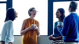 Four employees having a casual chat in office