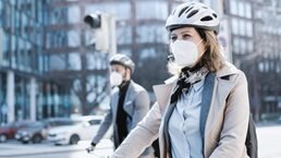 Businesspeople commuters wearing face masks with electric scooter and bicycle in city, crossing the road.