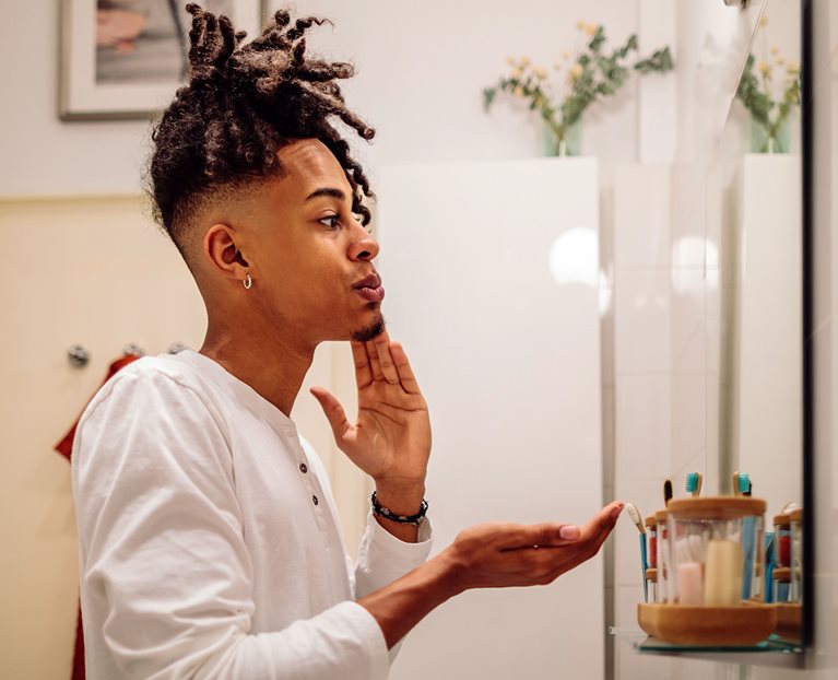 Person applying skincare in a mirror