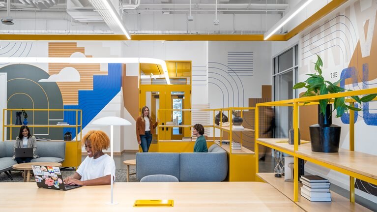 People working in a colorful, mixed-use workspace