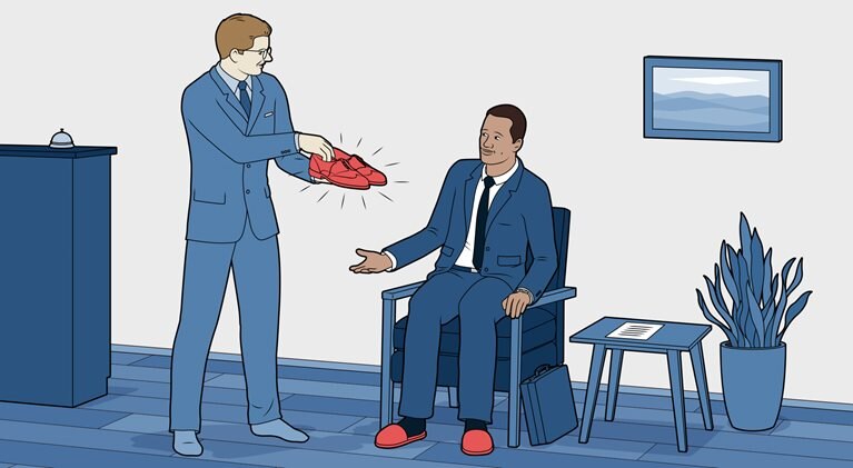 Hotel manager is offering a guest shoes to borrow.